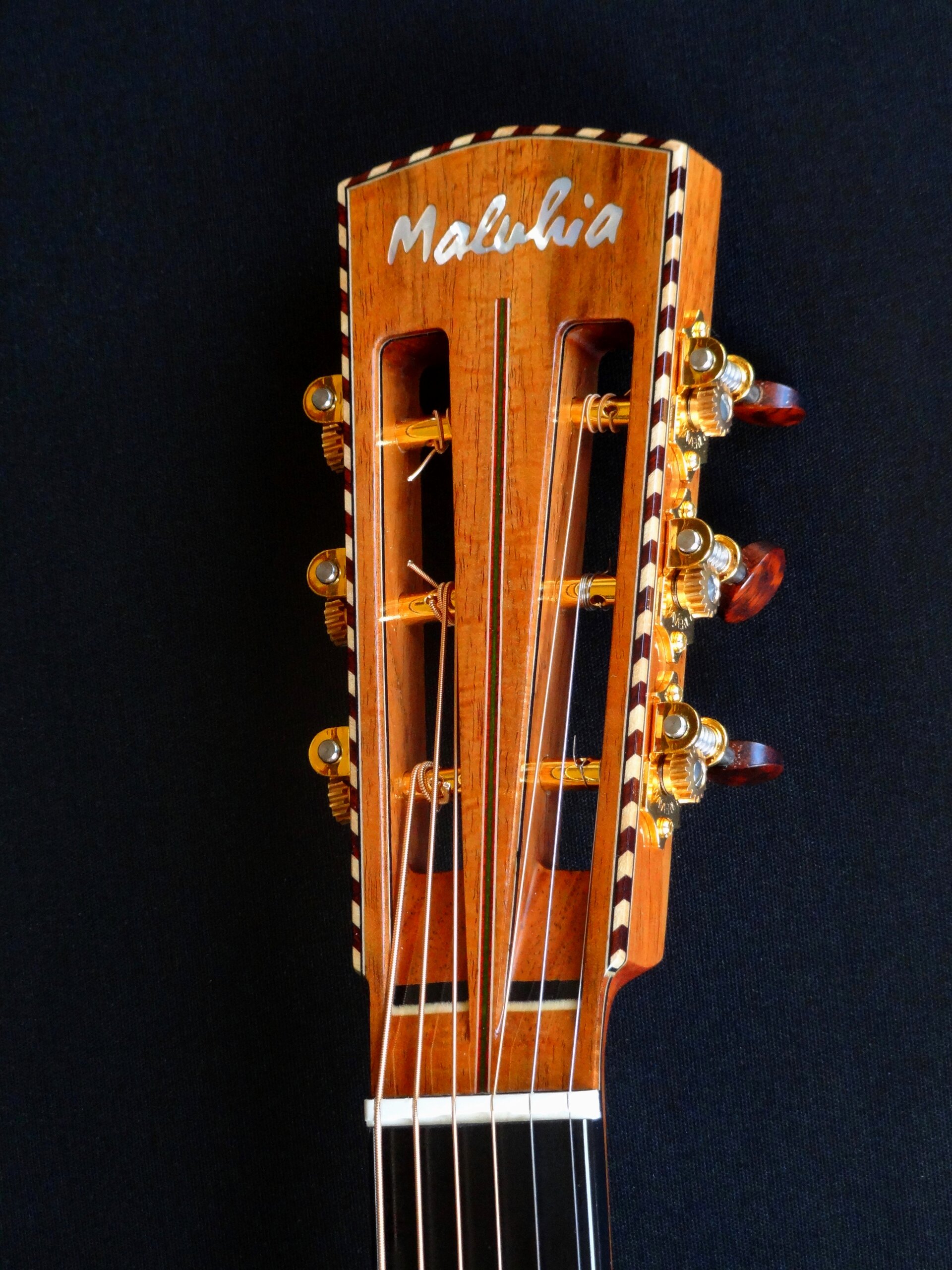 Slot headstock with rope binding, pearl inlay and Waverly tuners