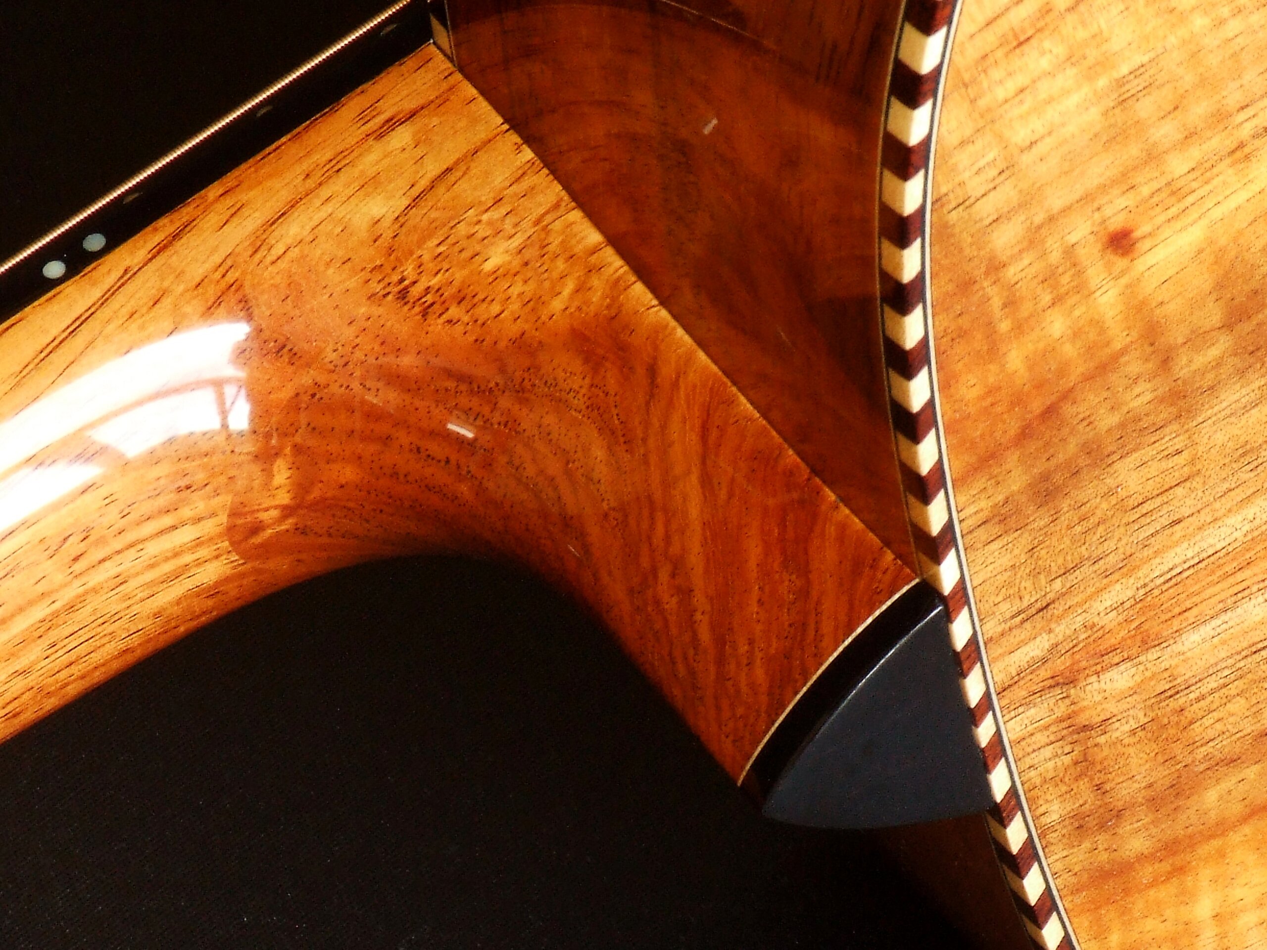 Neck heel detail on a guitar with rope binding
