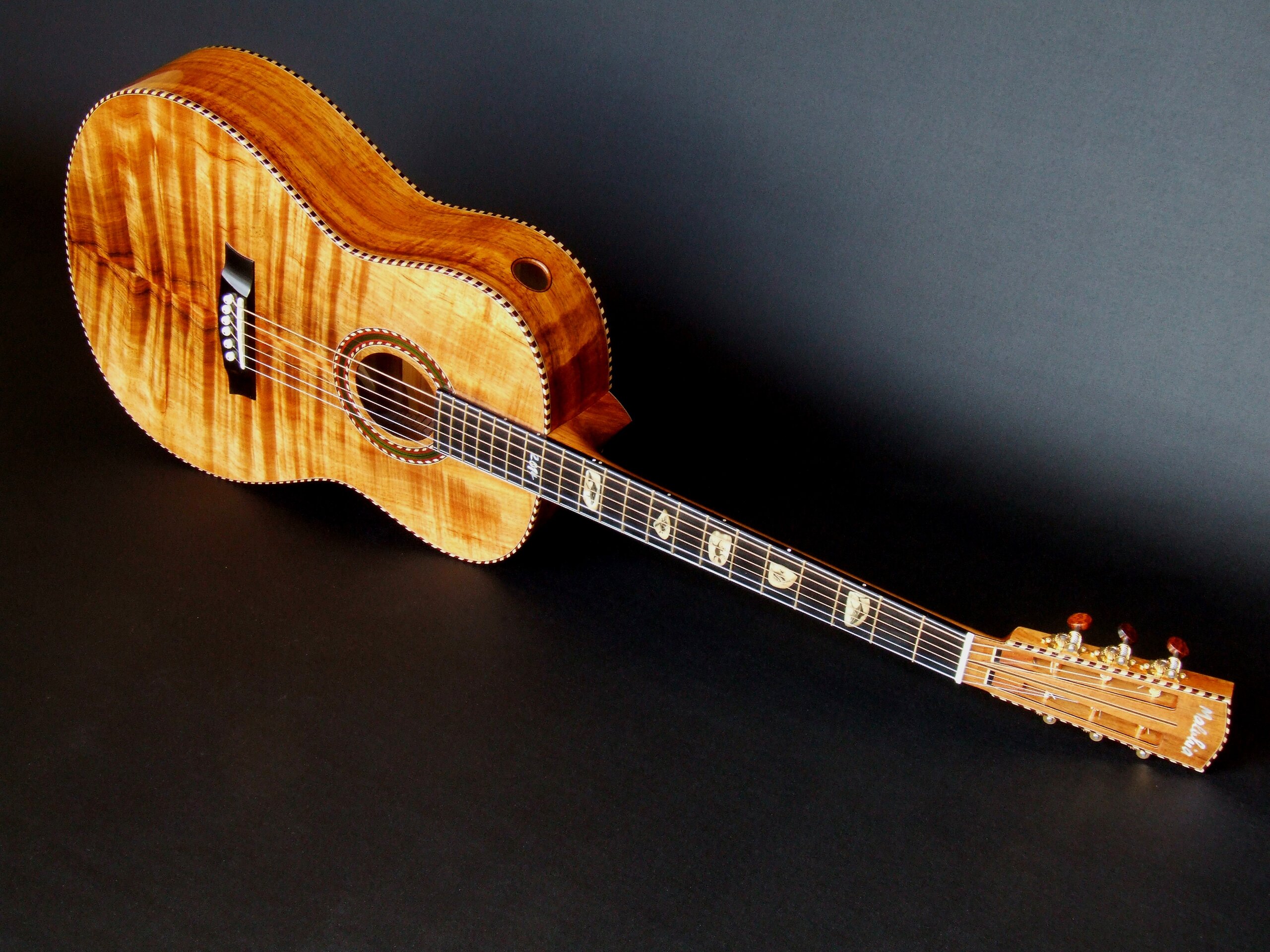 Koa top guitar with sound port and rope binding
