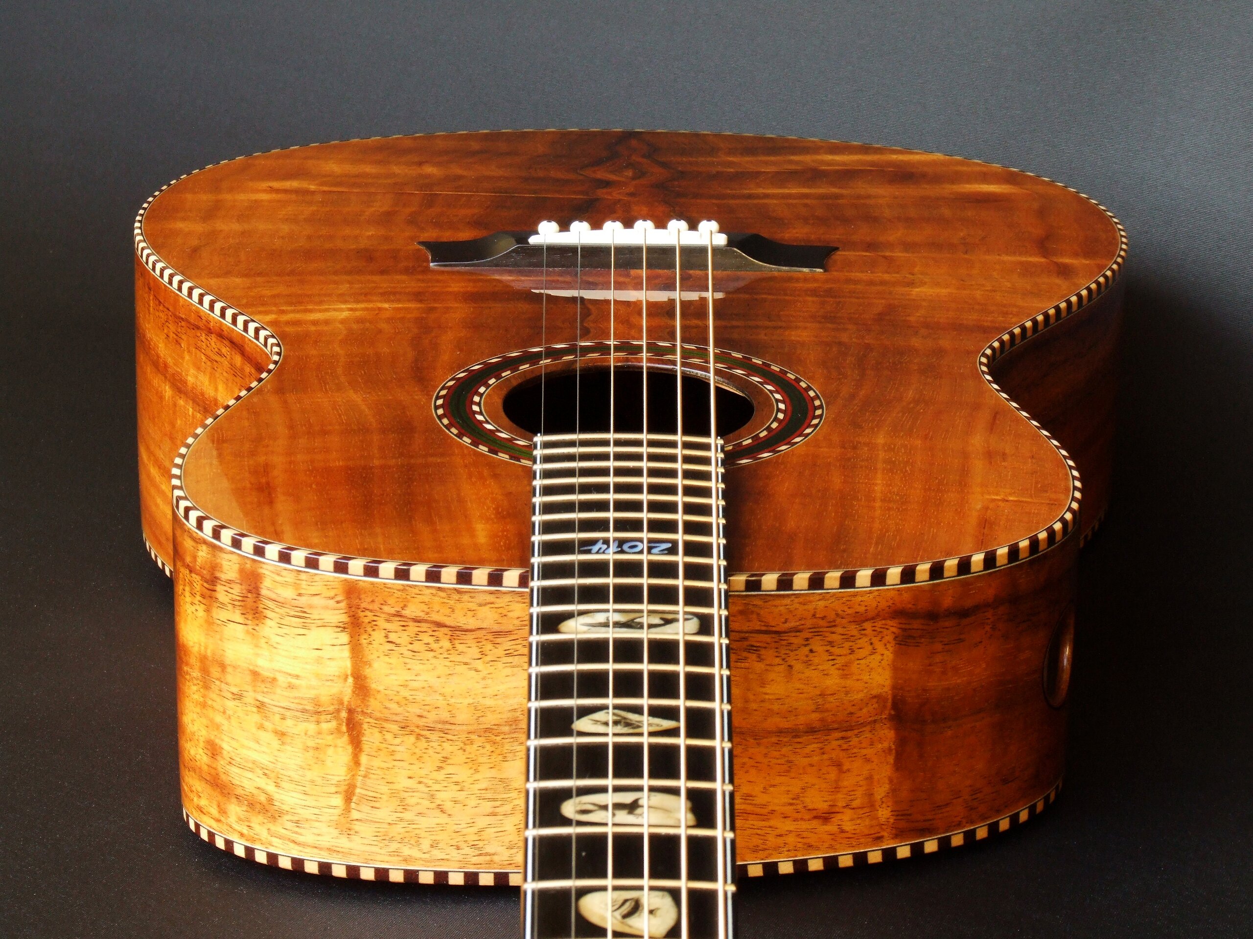 Custom guitars. Wedge-shaped body on a figured koa guitar by Trevor Gore