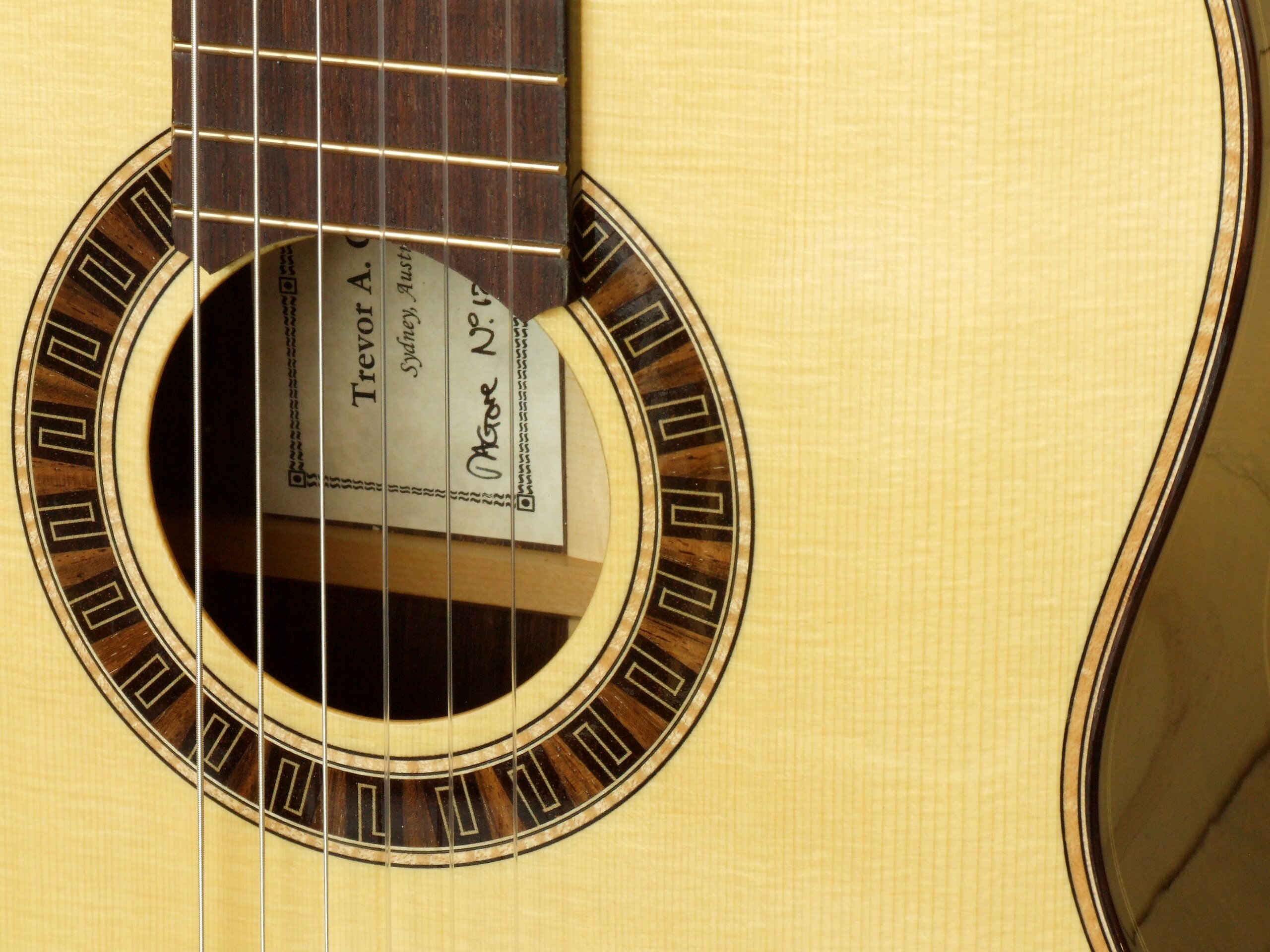 Custom guitars. Meander rosette, figured maple purfling in a spruce topped Gore classical guitar